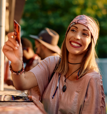 a woman smiling while holding a card to pay the bill